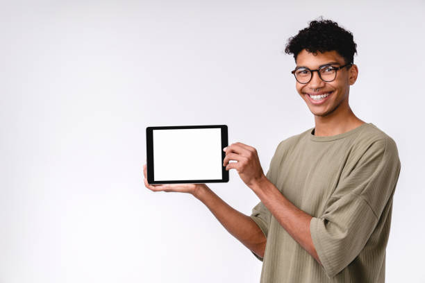istock Smart young mixed-race student showing tablet with blank screen isolated over white background 1301040618