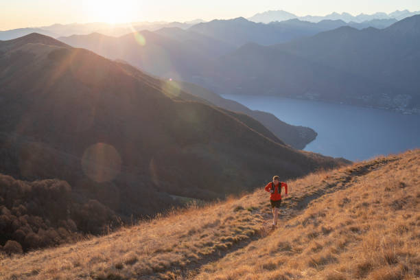 man runs above mountains and lake at sunrise - locarno imagens e fotografias de stock