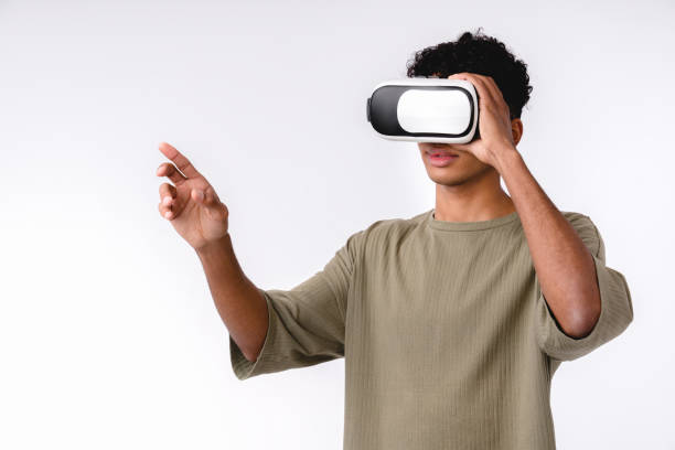 istock Young handsome african man using VR glasses isolated over white background 1301041395