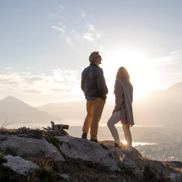istock Mature couple hike along sunny mountain ridge, sunset 1301041512
