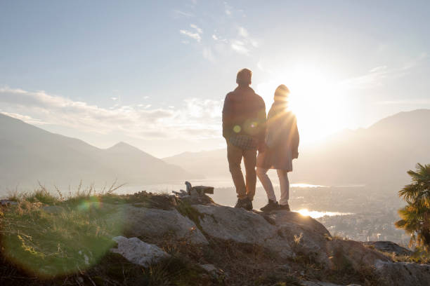 istock Mature couple hike along sunny mountain ridge, sunset 1301041552
