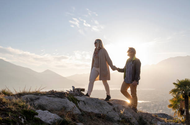istock Mature couple hike along sunny mountain ridge, sunset 1301041556