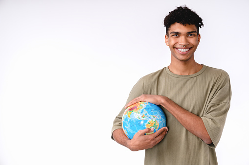 Cheerful young african man holding a globe to save the planet isolated over white background