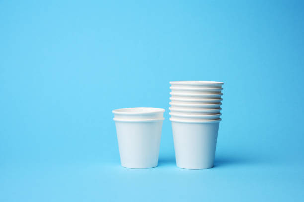 una pila di tazze di carta bianca su sfondo blu - disposable cup cup stack blue foto e immagini stock