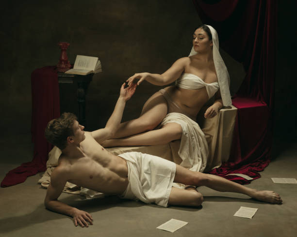 istock Modern remake of classical artwork - young medieval couple on dark background, comparison of eras concept 1301042310