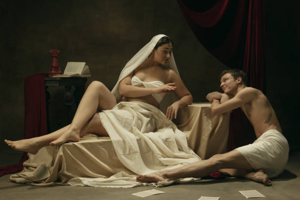 istock Modern remake of classical artwork - young medieval couple on dark background, comparison of eras concept 1301042347