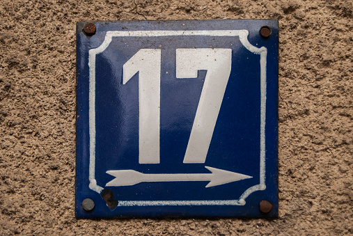 Weathered grunge square metal enamelled plate of number of street address with number 17