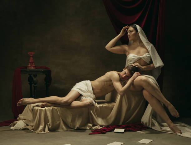 istock Modern remake of classical artwork - young medieval couple on dark background, comparison of eras concept 1301042406