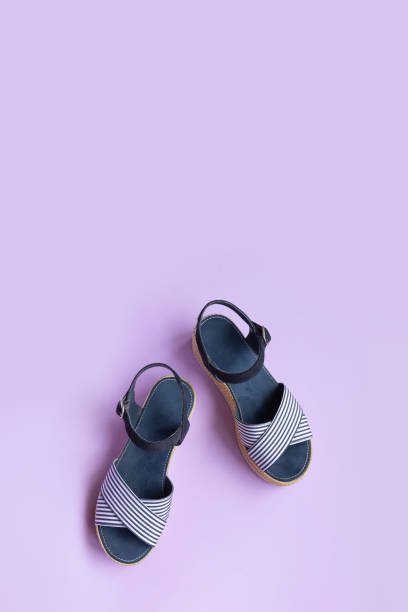istock Women's summer striped blue sandals on a lilac background with copy space. View from above. 1301043309