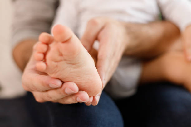 istock Father's hands carefully keeping baby's foot with tenderness 1301043455