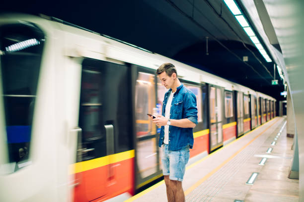 istock Serious man with smartphone standing near moving train 1301044302