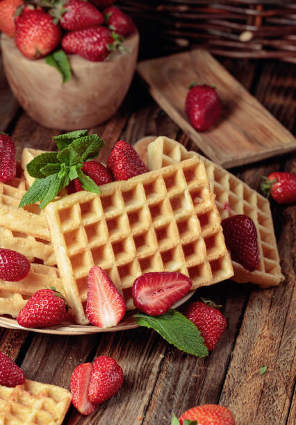 istock Waffles with strawberries and mint on a wooden table. 1301045822