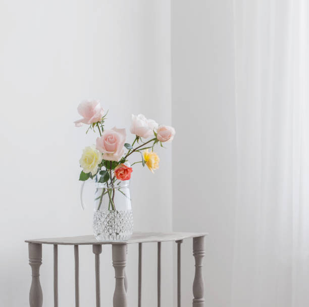 istock beautiful roses in glass jug on white background 1301046123