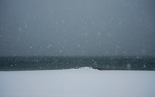 Snowscape with a heavy winter blizzard over the beach with jetty on Cape Cod, Massachusetts