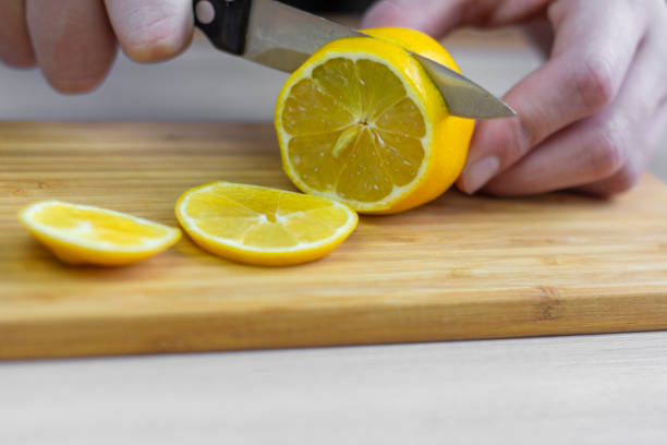 istock Cut the lemon.Men's hands slice a lemon. 1301046985
