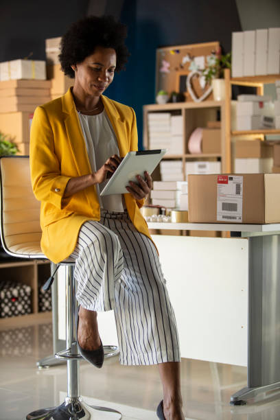 istock Businesswoman in a yellow blazer using digital tablet 1301047150