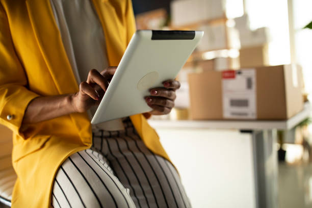 istock Midsection of businesswoman using digital tablet and working 1301047289