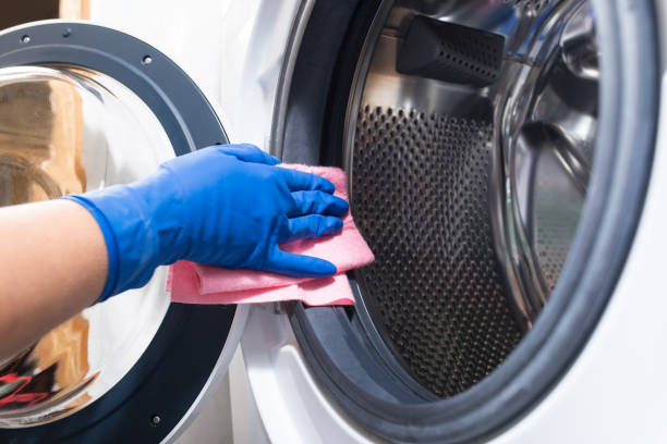Clean washer after using Hand in blue glovesw cleaning washing mashine with piece of cloth washing machine photos stock pictures, royalty-free photos & images