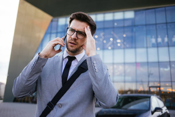 istock Pensive businessman talking on smart phone outdoors 1301047543