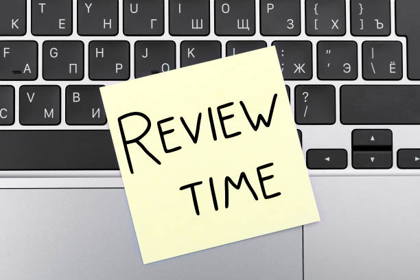 istock Words on yellow stickers REVIEW TIME on keyboard 1301048001