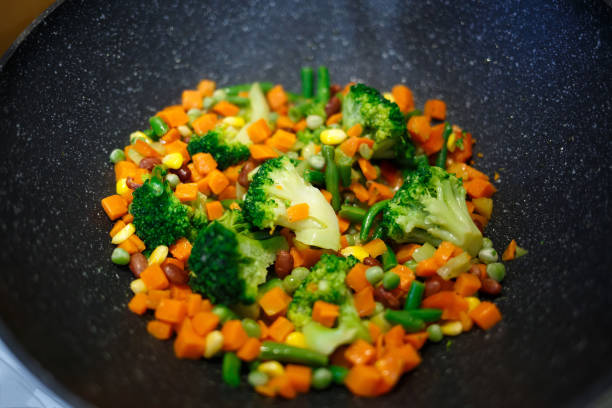 broccoli, carrots, beans, bell peppers and corn in a wok.