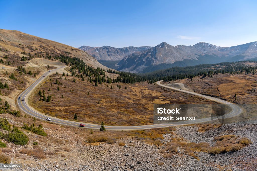 Autumn Mountain Road - A panoramic overview of a winding mountain road at east of the summit (12,126 ft/3,696 m) of Cottonwood Pass on a sunny Autumn afternoon. Buena Vista - Crested Butte, Colorado, USA. A panoramic overview of a winding mountain road at east of the summit (12,126 ft/3,696 m) of Cottonwood Pass on a sunny Autumn afternoon. Buena Vista - Crested Butte, Colorado, USA. Adventure Stock Photo