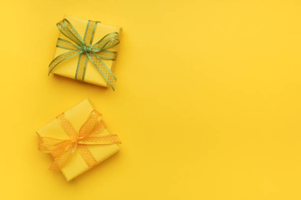 istock Gift boxes with ribbon and bow on yellow background and space for text. Top view 1301052704