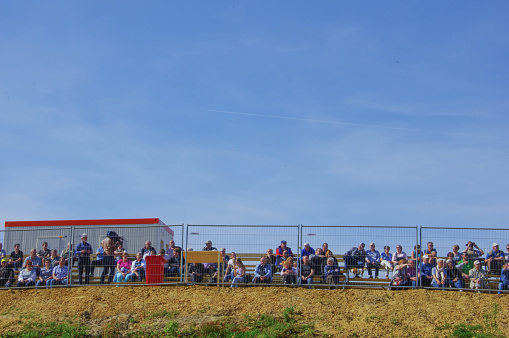 Kerkrade, the Netherlands, - May 06, 2018. People sitting on a tribune watching a special event for a road construction.