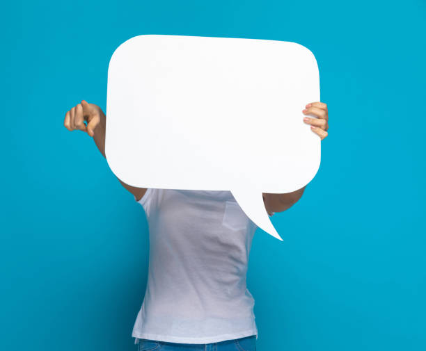 istock casual woman hiding behing a speech bubble and pointing 1301057066