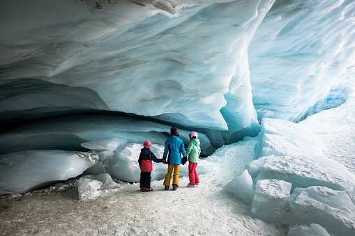 Family exploring an ice cave. Wonders of nature. Immersed in natures beauty.