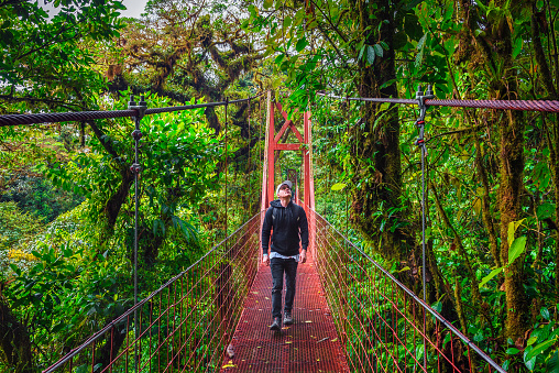 Tourist walking on a suspension bridge in Monteverde Cloud Forest, Costa Rica