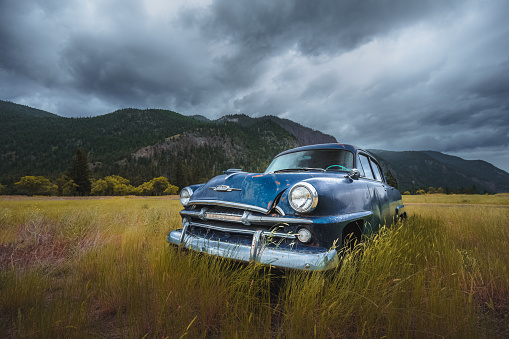 A classic vintage Plymouth blue car sits abandoned in the Similkameen countryside near Hedley British Columbia, Canada.