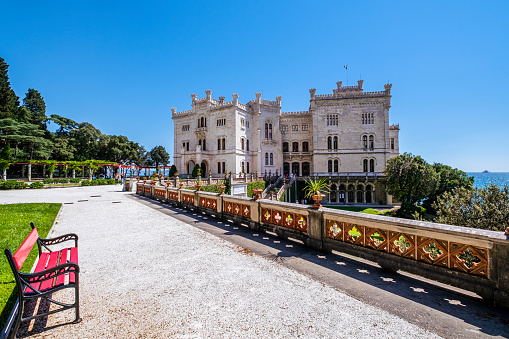 The Miramare Castle is a 19th-century castle facing directly on the Gulf of Trieste, with grounds that include an extensive cliff and a seashore park. Tourists visiting.