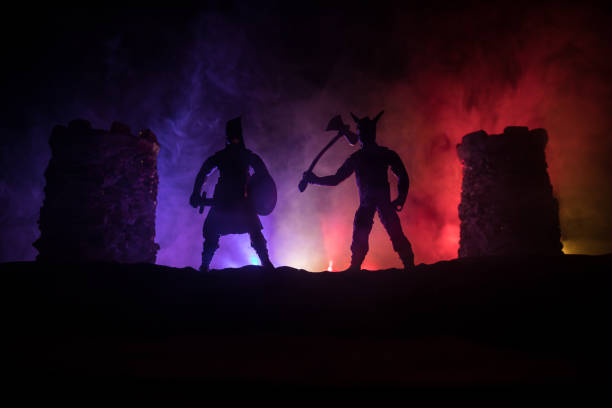 istock Medieval battle scene. Silhouettes of figures as separate objects, fight between warriors at night. Creative artwork decoration. Foggy background. 1301060186