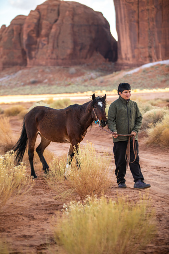 Navajo teenager with his horse in Monument Valley
