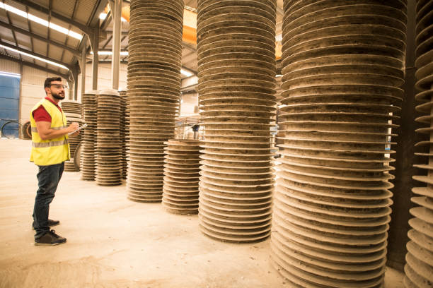 Man in construction warehouse counting and inspecting tubes.