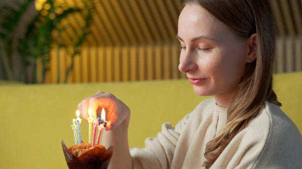 istock Woman lights a candle on a delicious cake 1301062410