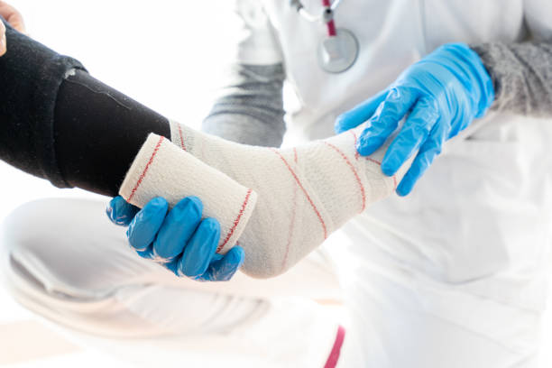 istock Unrecognizable doctor bandaging leg of elderly patient 1301063627