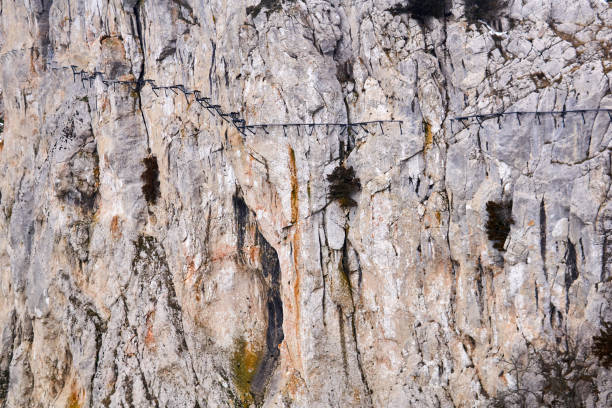 istock background - the surface of a huge cliff with a destroyed hanging path on it 1301064815
