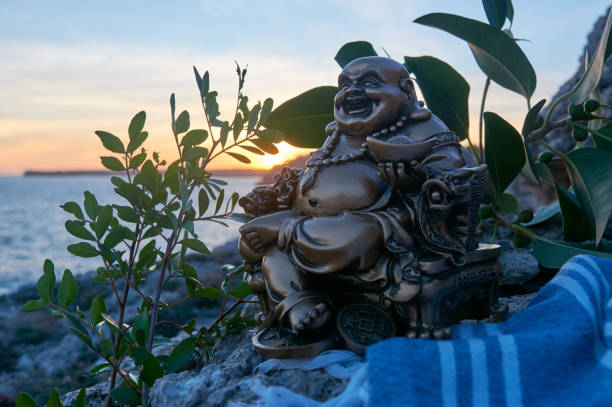istock Buddha figure, at sunset, on a cliff in the sea 1301065413