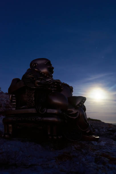 istock Buddha figure, under the moonlight, on a cliff in the sea 1301065439