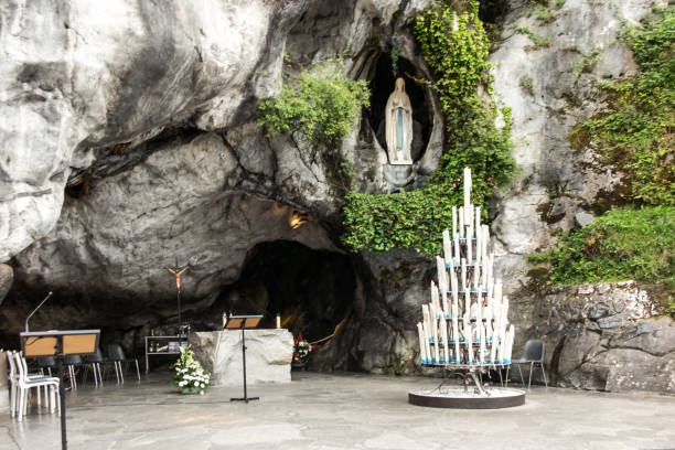 statue unserer lieben frau von der unbefleckten empfängnis mit einem rosenkranz in der grotte von massabielle in lourdes - grotte stock-fotos und bilder
