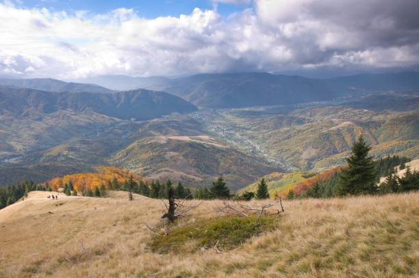 Mountain autumn landscape with colorful forest and a village far in the valley stock photo