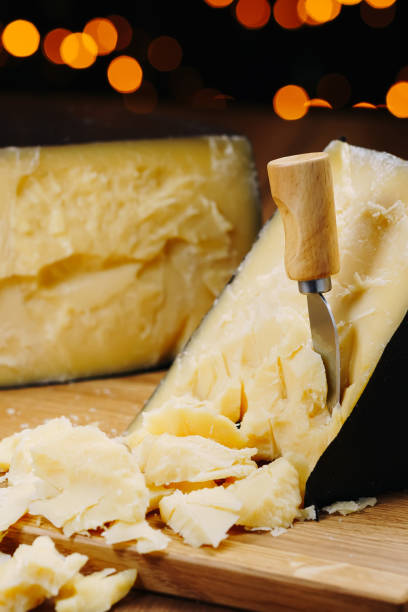 istock Medium hard cheese head parmesan on wooden board, with cheese parmesan knifes 1301068076