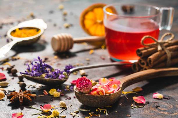 Black tea cup and herbal tea featuring rose petals tea and mallow Black tea cup and herbal tea featuring rose petals tea and mallow, anise, calendula, dried orange and many spices on the table malva stock pictures, royalty-free photos & images