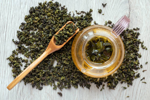 istock Top view brewing green tea in a glass teapot. 1301069190