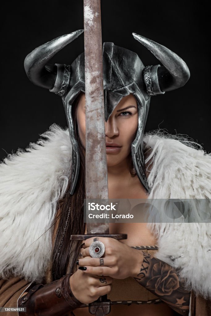 Beautiful fantasy Viking Woman Beautiful brunette Sword wielding fantasy horned helmet viking warrior female Viking Helmet Stock Photo