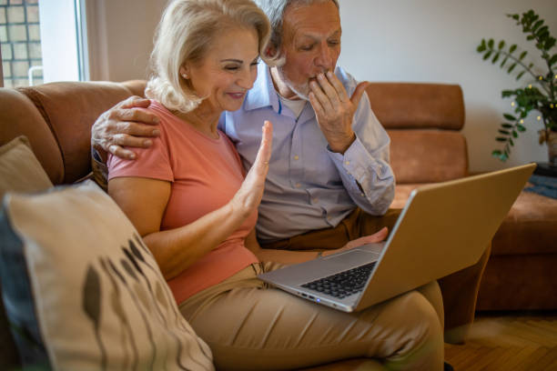 istock Happy senior couple at home, using laptop 1301069683