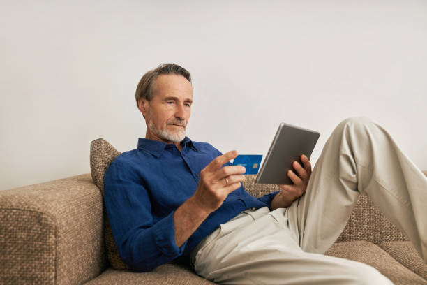 istock Mature man doing online payment from digital tablet 1301069824