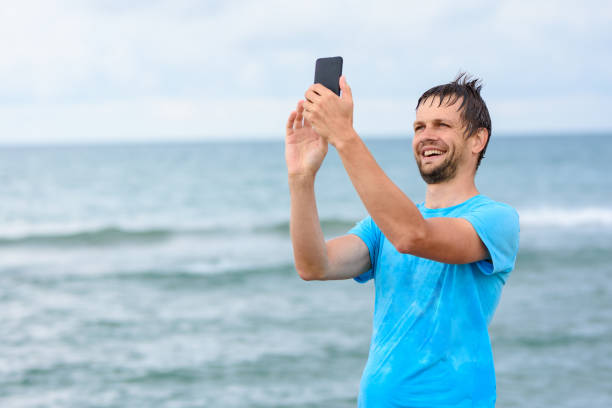 istock A man communicates via video communication using a mobile phone while relaxing on the sea 1301070980